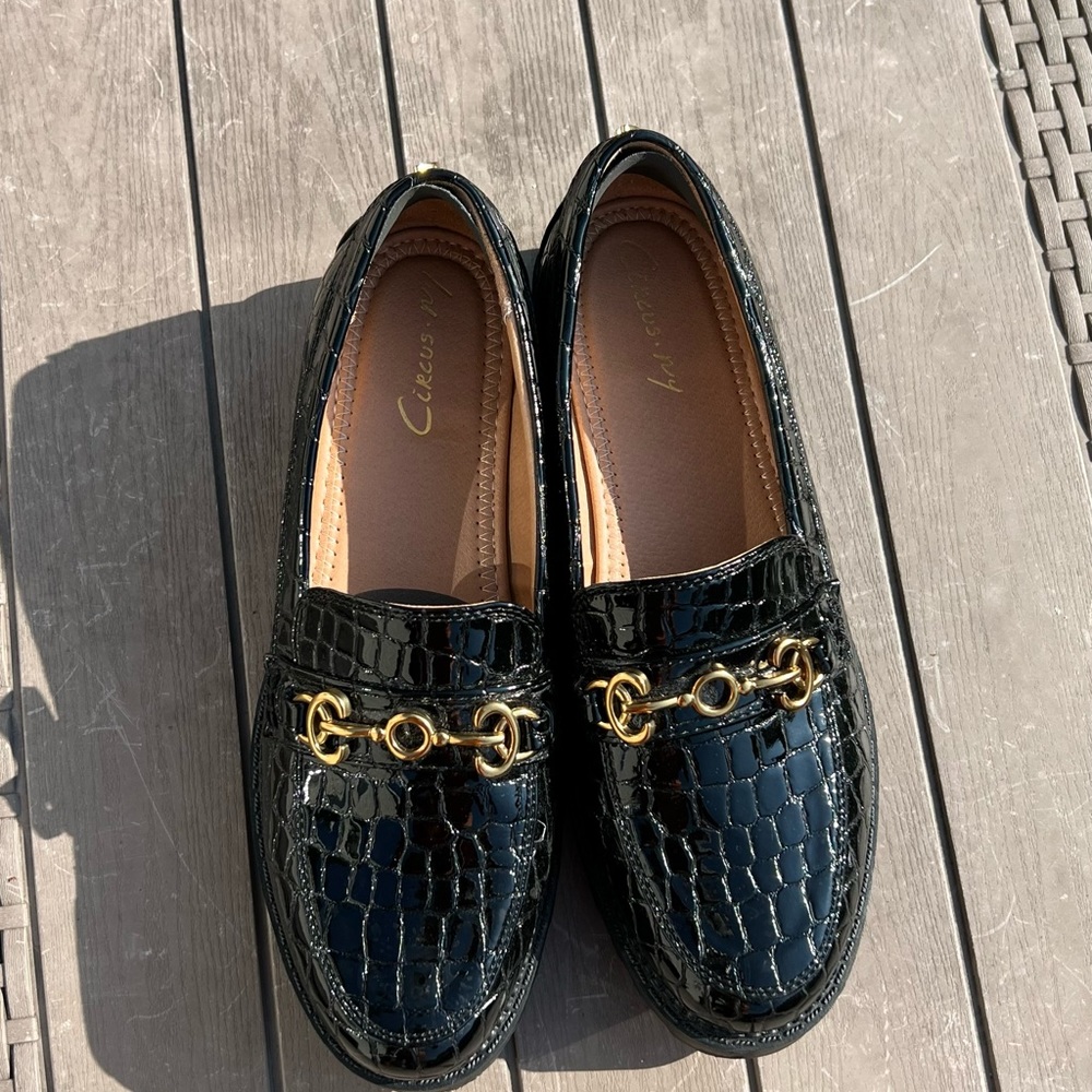Black loafers with a gold detailing